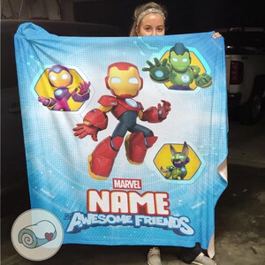 Peut inclure: Une couverture bleu clair avec des illustrations de dessins anim&eacute;s d'Iron Man et d'autres personnages Marvel. La couverture porte le texte "MARVEL NAME Awesome Friends". La couverture est en mati&egrave;re douce.