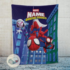 May include: A navy blue blanket featuring Spider-Man and friends. The blanket has a cityscape background with the text "MARVEL NAME AMAZING FRIENDS". The design includes Spider-Man, Spider-Gwen, and Miles Morales.