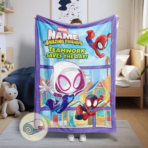 Op de afbeelding: Een blauwe en paarse Marvel-deken met Spider-Man-personages. De deken heeft de tekst "Marvel Amazing Friends Teamwork Saves the Day!" en een cartoonillustratie van Spider-Man, Spider-Gwen en Miles Morales.