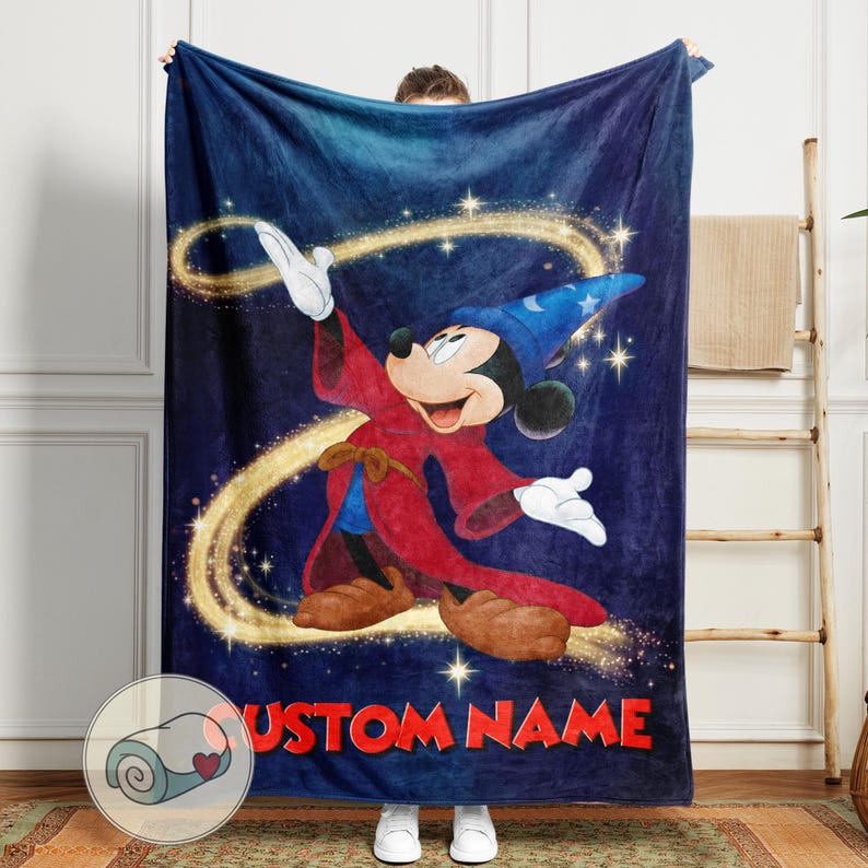 Op de afbeelding: Een marineblauwe fleece deken met een cartoonafbeelding van Mickey Mouse verkleed als tovenaar. Het ontwerp omvat een blauwe tovenaars hoed, rode mantel en de tekst "CUSTOM NAME" in het rood. Gouden glitters en een wervelend ontwerp maken het magische thema compleet.
