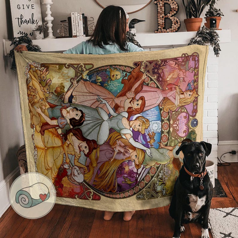 Peut inclure: Une grande couverture rectangulaire avec une illustration de style vitrail de plusieurs princesses Disney en robes. La couverture a une bordure cr&egrave;me et une image enroul&eacute;e dans le coin.
