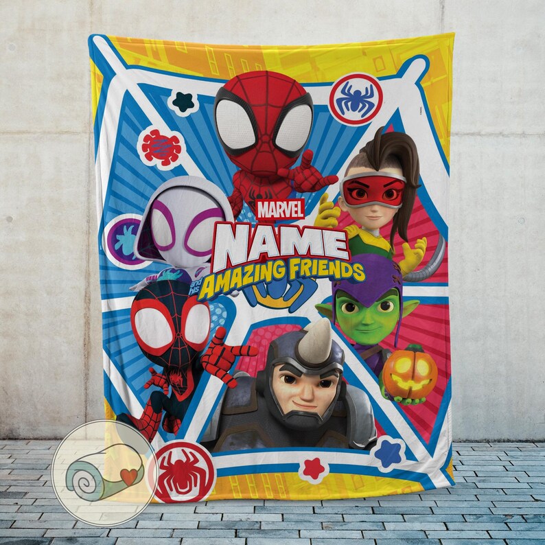 May include: A colorful Marvel Amazing Friends blanket featuring Spider-Man and other characters. The blanket has a blue, yellow, and white geometric background with the Marvel logo and the text "NAME" and "AMAZING FRIENDS".