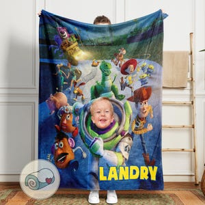 Peut inclure: Une couverture en polaire bleue avec des personnages du film d'animation Toy Story. La couverture porte le nom personnalis&eacute; "Landry" en lettres jaunes. Le motif comprend des images de Buzz l'&Eacute;clair, Woody et d'autres personnages.