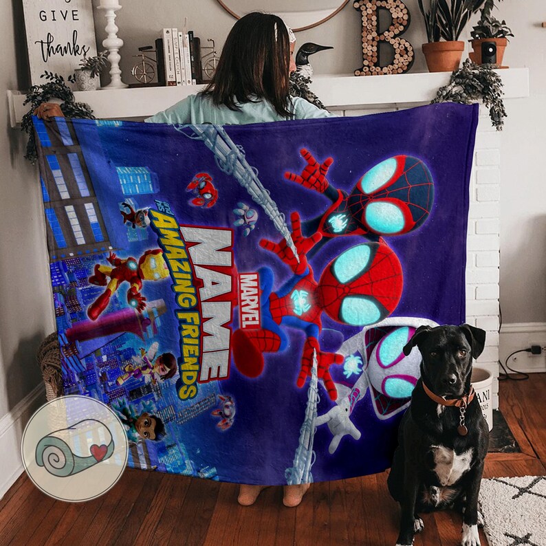 May include: A plush, blue blanket featuring Spider-Man and other Marvel characters. The blanket has the words "Amazing Friends" and "Marvel" printed on it. The design includes a cityscape background and various action poses.