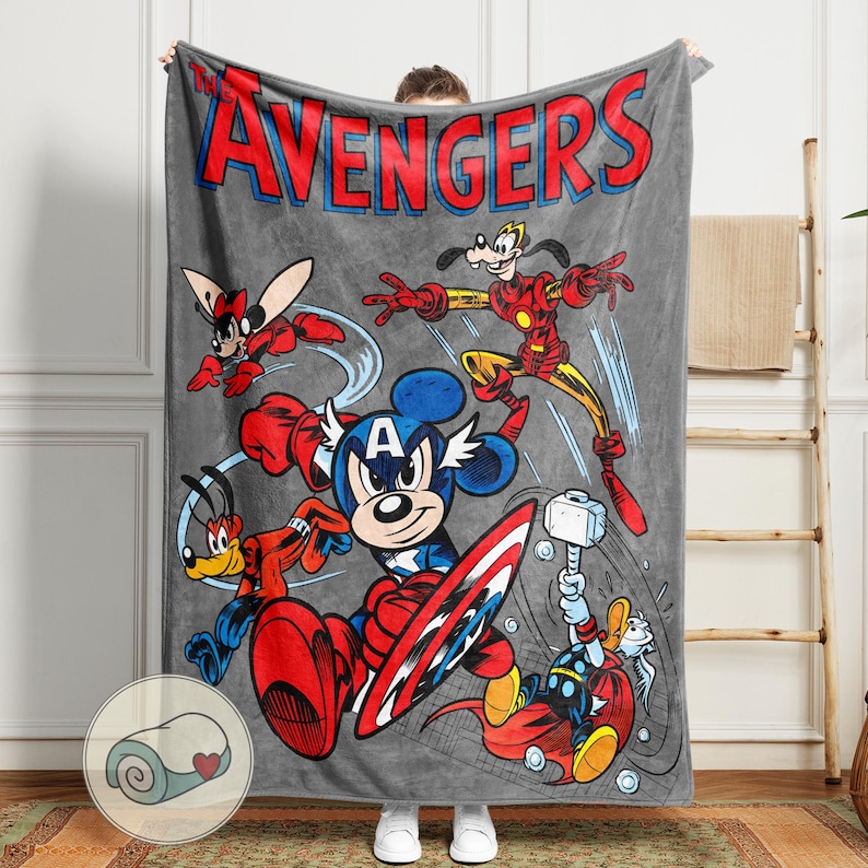 May include: A gray blanket featuring a cartoon illustration of Avengers characters, including Mickey Mouse as Captain America, Iron Man, and Thor. The word "AVENGERS" is printed in red and blue at the top. The blanket is made of a soft material.