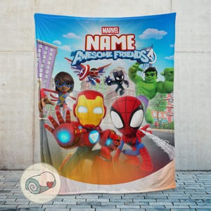 May include: A blue Marvel blanket featuring the text "MARVEL NAME AWESOME FRIENDS 4" and illustrations of Iron Man, Spider-Man, and other superheroes. The blanket has a cityscape background and a rolled-up blanket graphic in the corner.