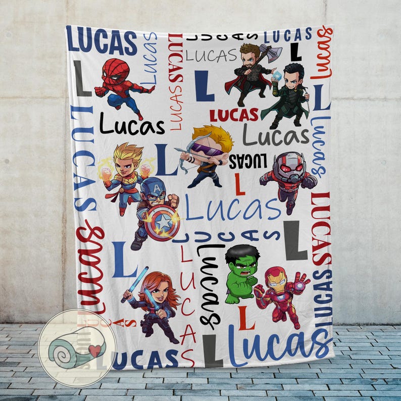 Puede incluir: Manta blanca con superh&eacute;roes de dibujos animados y el nombre "Lucas" en azul y rojo. El dise&ntilde;o incluye personajes como Spider-Man, Capit&aacute;n Am&eacute;rica e Iron Man. La palabra "Lucas" se repite.