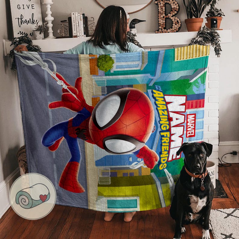 May include: A colorful blanket featuring the Marvel character Spider-Man. The design includes a large image of Spider-Man in action, with the words "Name" and "Amazing Friends" in bold letters. The blanket has a cityscape background.