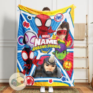 May include: A Marvel "Amazing Friends" blanket featuring Spider-Man and other characters. The blanket has a blue and yellow background with character illustrations and the text "NAME AMAZING FRIENDS".