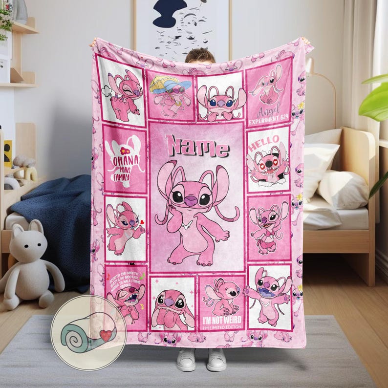 May include: Pink fleece blanket featuring the character Angel from Lilo & Stitch. The blanket has a grid design with various images of Angel, the text "Name", and other phrases. The blanket is a soft, cozy item.