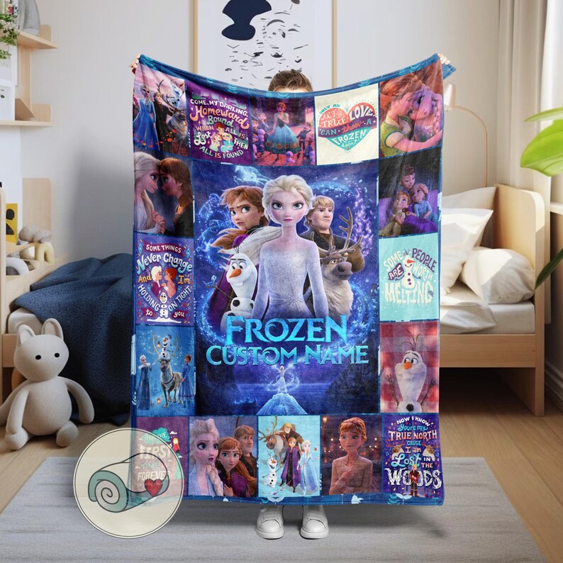 Puede incluir: Una manta polar azul con personajes de la pel&iacute;cula "Frozen". La manta tiene una imagen central de Elsa, Anna, Olaf y Kristoff, rodeada de im&aacute;genes m&aacute;s peque&ntilde;as y texto de la pel&iacute;cula. Tambi&eacute;n son visibles las palabras "Frozen Custom Name".