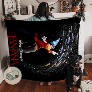 Peut inclure: Couverture noire avec Mickey Mouse de Fantasia de Disney, v&ecirc;tu d'une robe rouge et d'un chapeau de magicien bleu, sur fond &eacute;toil&eacute;. Le mot "Fantasia" et "Walt Disney's" sont imprim&eacute;s sur la couverture.