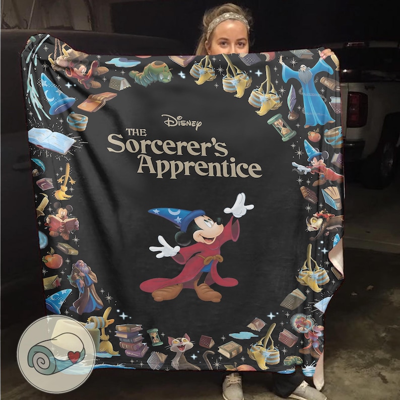 Pu&ograve; includere: Una coperta nera con Topolino in abito da mago da "L'apprendista stregone" di Disney. La coperta ha un bordo di oggetti e personaggi magici del film, con il testo del titolo ben visibile.