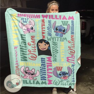 May include: A light blue blanket featuring cartoon characters and the name "William" in various colors. The blanket has a grid pattern and includes images of Stitch and Lilo.
