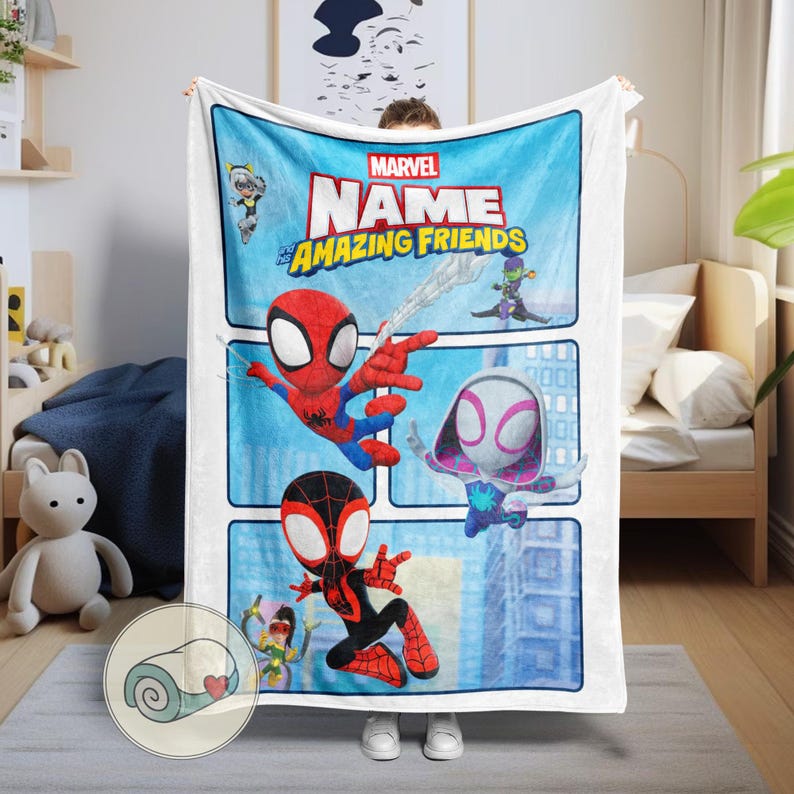 May include: A white Marvel "Amazing Friends" blanket featuring Spider-Man, Spider-Gwen, and Miles Morales. The blanket has a blue background with comic book style panels and the Marvel logo. The blanket is made of a soft material.