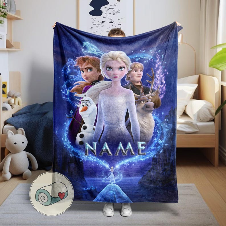 Pu&ograve; includere: Una coperta in pile blu navy con personaggi del film d'animazione Frozen. La coperta ha un design a forma di cuore con la scritta "NAME" al centro. Un articolo accogliente e decorativo.