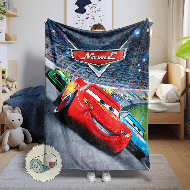 May include: A plush blanket featuring a vibrant image of the animated movie Cars. The design showcases Lightning McQueen in red, along with other race cars on a racetrack. The blanket has a blue background with the word "Name" on it.