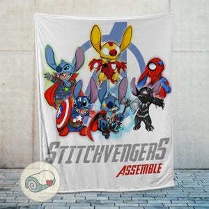Puede incluir: Manta blanca con personajes de dibujos animados disfrazados de superh&eacute;roes. La manta tiene el texto "Stitchvengers Assemble" en gris y rojo. Los personajes incluyen a Stitch como Capit&aacute;n Am&eacute;rica, Thor, Iron Man y otros.