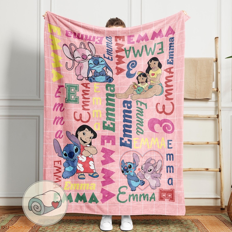 May include: Pink fleece blanket featuring cartoon characters and the name "Emma" in various colors and fonts. The blanket has a grid pattern and includes images of Stitch and Lilo.