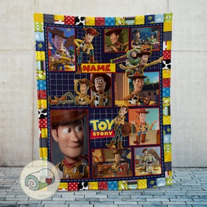 May include: A colorful, patchwork-style blanket featuring images of Woody from the animated film "Toy Story." The blanket has a navy blue background with various character poses and the words "Toy Story" and "Name" displayed. The border is a mix of patterns.