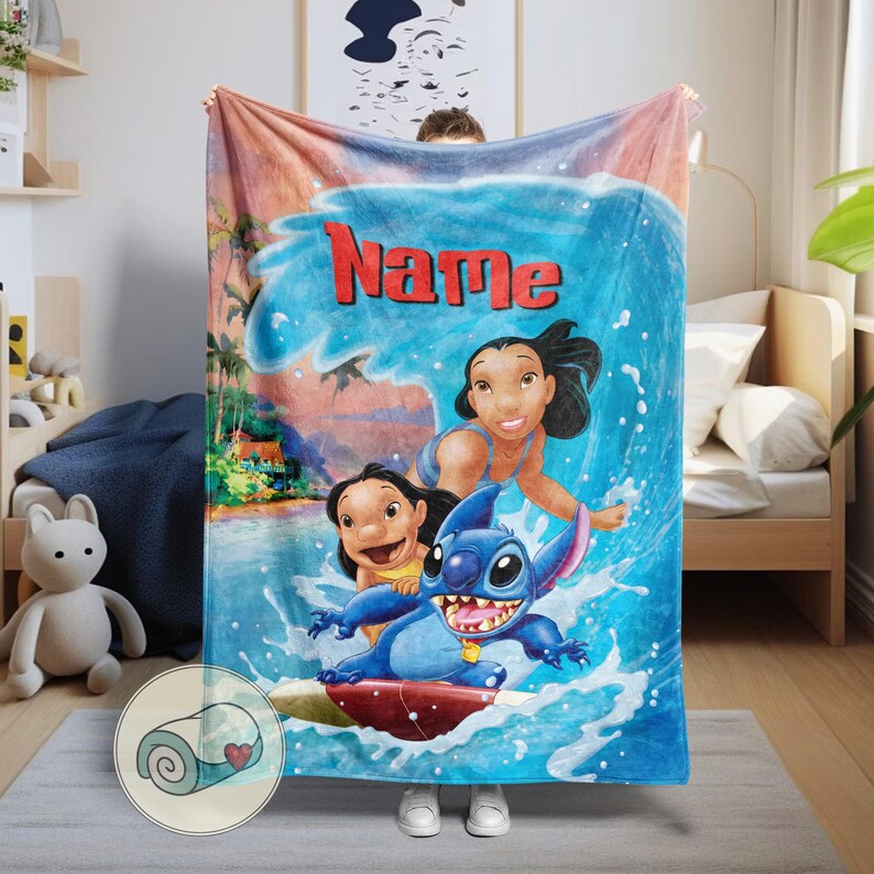 May include: A blue blanket featuring a cartoon scene with the word "Name" in red. The design includes characters, a blue wave, and a tropical background. The blanket is held up by a person.