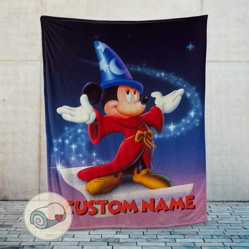 Pu&ograve; includere: Una grande coperta rettangolare con una vivace illustrazione di Topolino vestito da mago. Mickey indossa un cappello blu e una veste rossa, con uno sfondo stellato. Il testo "CUSTOM NAME" &egrave; in basso.