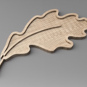 Puede incluir: Una bandeja de madera con forma de hoja y superficie texturizada. La bandeja es de color marrón claro y tiene un contorno detallado, con un tallo que se extiende desde la base. El diseño de la hoja es de forma natural y orgánica.