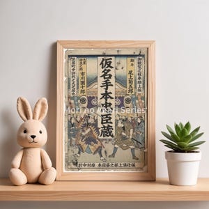 May include: A framed Japanese woodblock print featuring a historical scene with figures in traditional attire. The print is in a light wood frame and is displayed on a wooden shelf with a plush bunny and a potted succulent.