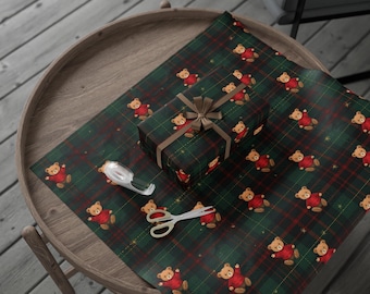 May include: A wrapped gift and wrapping paper featuring a green and red plaid pattern with repeating illustrations of teddy bears wearing red sweaters. A roll of tape and scissors are also on the table.