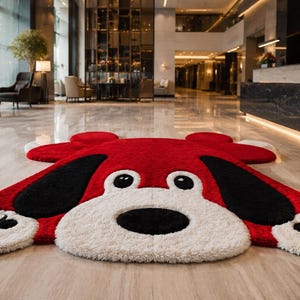 May include: A red dog-shaped rug with black ears and a white face and paws. The rug is made of a soft, plush material and is designed to resemble a cartoon dog. The rug is on a polished floor.