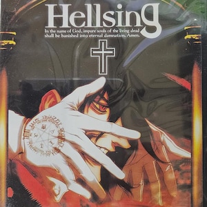 May include: DVD case for "Hellsing: The Perfect Collection" with a dark, gothic design. The cover features a stylized illustration of a character with red eyes and a cross, with the title text "Hellsing".