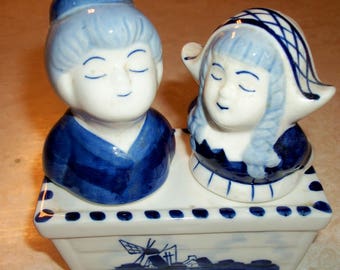 Handpainted Delft Blue girl and boy Salt and Pepper set in holder.