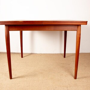 May include: A rectangular wooden table with a warm brown finish. The table has four slender, tapered legs and a simple, minimalist design. The table is set against a neutral background.
