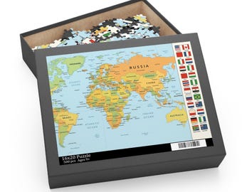Op de afbeelding: Een zwarte doos met een wereldkaartpuzzel. De puzzel toont een gedetailleerde kaart met landen in verschillende kleuren. De doos bevat ook losse puzzelstukjes. De doos leest "16x20 Puzzle 500 pcs Ages 9+" en heeft een barcode.