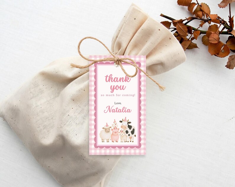 Pink farm thank you tag with watercolor cow, pig, sheep and chicken attached to a gift bag with twine.