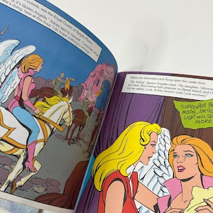 May include: Comic book pages with colorful illustrations. One panel shows a woman on a winged horse, while another depicts two women in distress. Text bubbles contain dialogue. The comic book is open, displaying multiple panels.