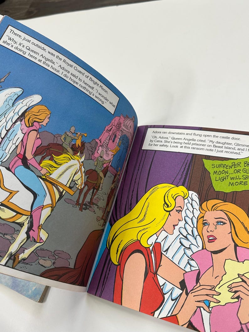 May include: Comic book pages with colorful illustrations. One panel shows a woman on a winged horse, while another depicts two women in distress. Text bubbles contain dialogue. The comic book is open, displaying multiple panels.