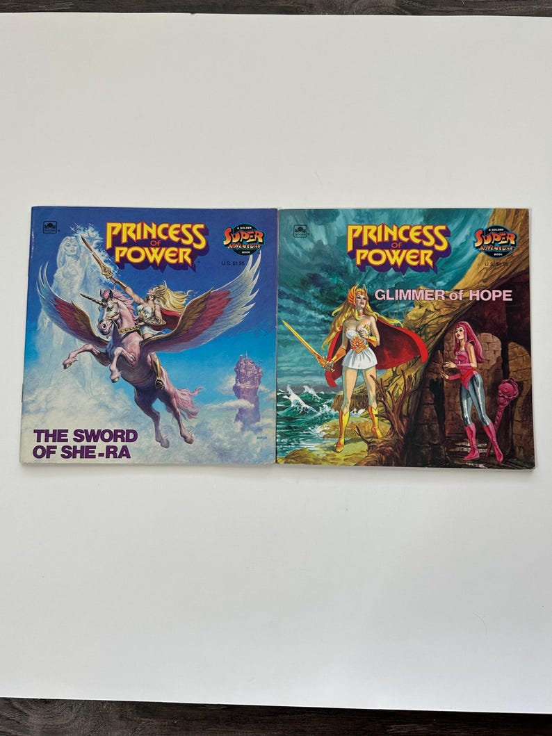 May include: Two vintage "Princess Power" comic books. The first cover features a character riding a winged horse, with the text "The Sword of She-Ra." The second cover shows a woman with a sword, with the text "Glimmer of Hope."