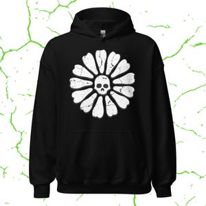 May include: Black hooded sweatshirt featuring a white distressed floral design with a skull in the center. The graphic is centered on the front of the sweatshirt. The sweatshirt has a drawstring hood and a kangaroo pocket.