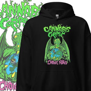 Può includere: Felpa con cappuccio nera con grafica verde e rosa. Il design include il testo "Cannabis Corpse" e un'illustrazione di un mostro verde che tiene in mano un globo. Sono visibili anche le parole "Choice Nugs".
