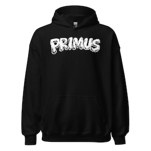 May include: Black hooded sweatshirt with the white text "PRIMUS" across the chest. The text has a distressed, textured appearance. The sweatshirt has a front pocket and a drawstring hood.