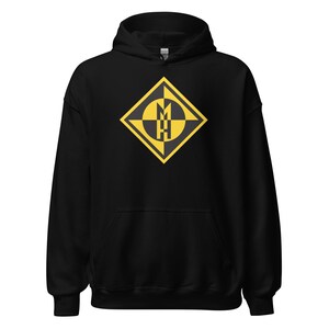 May include: Black hooded sweatshirt with a yellow and black geometric design on the front. The design features a diamond shape with a stylized letter "M" and "H" inside. The sweatshirt has a drawstring hood and a front pocket.