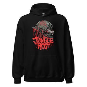 May include: Black hooded sweatshirt with a graphic design. The design features a military helmet with a peace symbol and bullets, with the words "Jungle Rot" in red dripping letters.