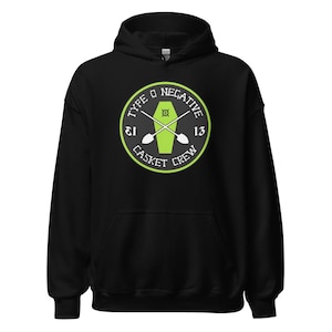 May include: Black hooded sweatshirt featuring a circular graphic with the text "TYPE O NEGATIVE" and "CASKET CREW" in white and green. The graphic includes a coffin and crossed shovels. The number "13" is on the right side of the graphic.