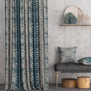 May include: Teal and cream patterned curtain with a repeating abstract design. A bench with cushions, a shelf with plates, and two wooden boxes are also visible. The scene is set against a concrete wall.