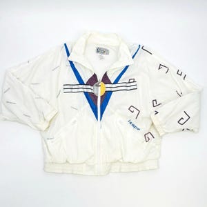 May include: White vintage jacket with a full zipper, featuring a stand-up collar and elastic cuffs. The jacket has a geometric design in blue, purple, and yellow, with the brand name "ixspa" visible. The jacket has a retro aesthetic.