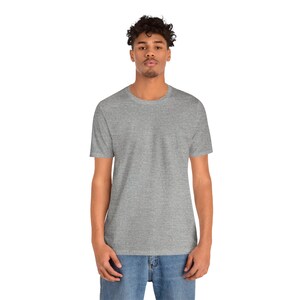 Peut inclure: Un t-shirt gris chin&eacute; &agrave; col rond. Le t-shirt &agrave; manches courtes est fait d'une mati&egrave;re douce et est port&eacute; avec un jean bleu. Le mod&egrave;le se tient devant un fond blanc.