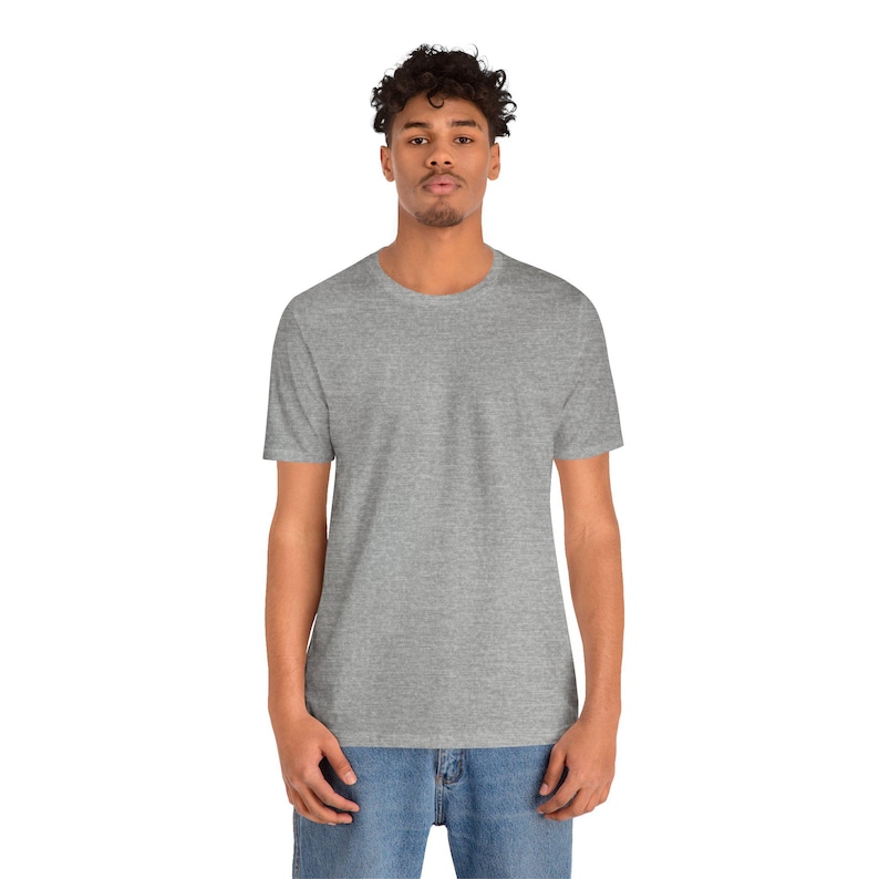 Peut inclure: Un t-shirt gris chin&eacute; &agrave; col rond. Le t-shirt &agrave; manches courtes est fait d'une mati&egrave;re douce et est port&eacute; avec un jean bleu. Le mod&egrave;le se tient devant un fond blanc.