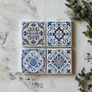 May include: Four square ceramic tiles arranged in a grid, each featuring a distinct blue, white, and yellow intricate floral and geometric pattern. The tiles display symmetrical designs with ornate scrollwork, petals, and central motifs.
