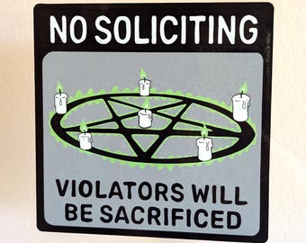 May include: A black and white sign with the text "NO SOLICITING" in white letters. The sign also features a black pentagram with five white candles around it. The text "VIOLATORS WILL BE SACRIFICED" is below the pentagram.